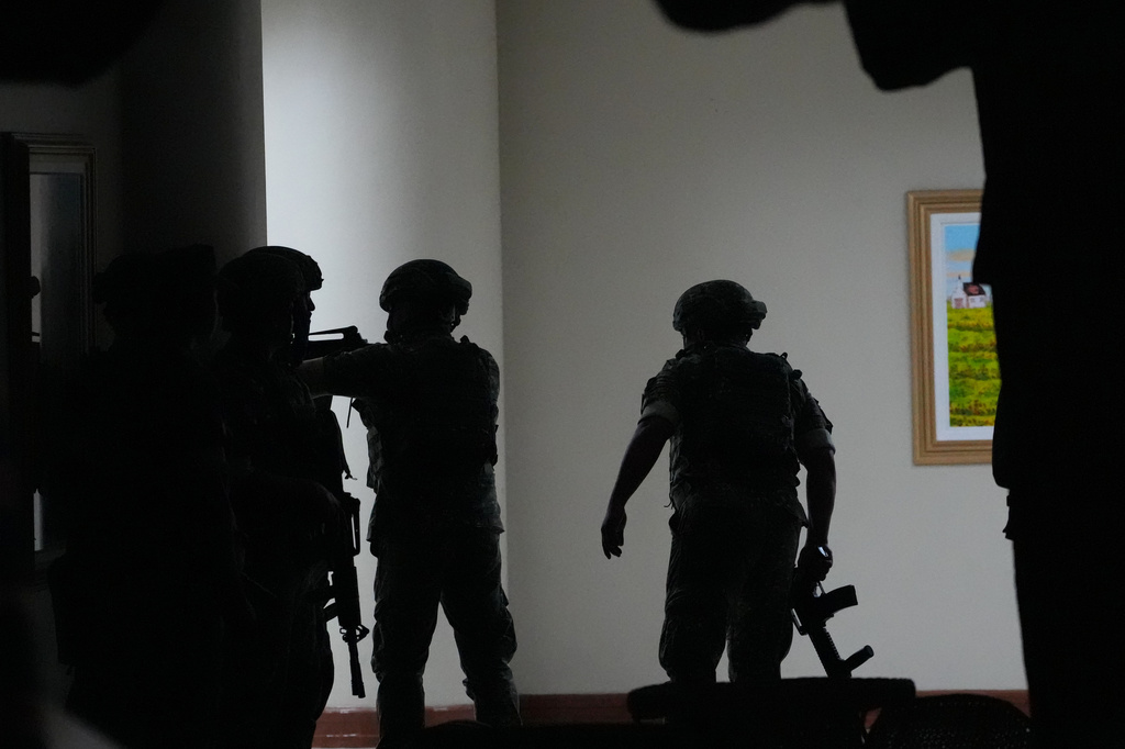 Philippine troopers exchange fire along a hallway at the Philippine Senate in Pasay, Philippines on Wednesday May 13, 2026. (AP Photo/Aaron Favila)