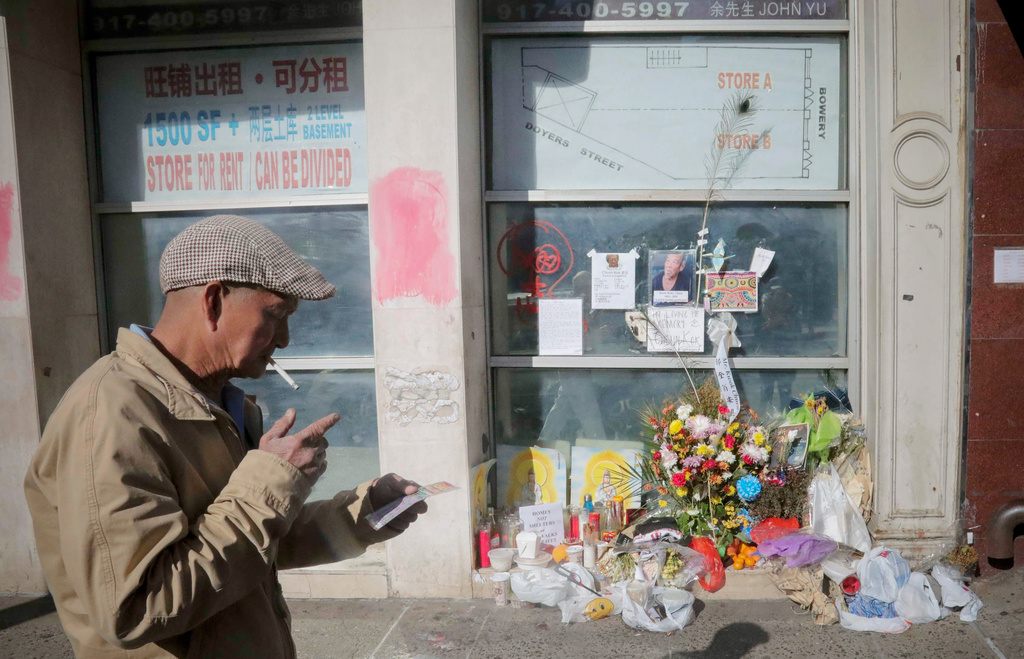 FILE - A man walks past a makeshift memorial made for Chuen Kok, Oct. 18, 2019, in New York. (AP Photo/Bebeto Matthews, File)