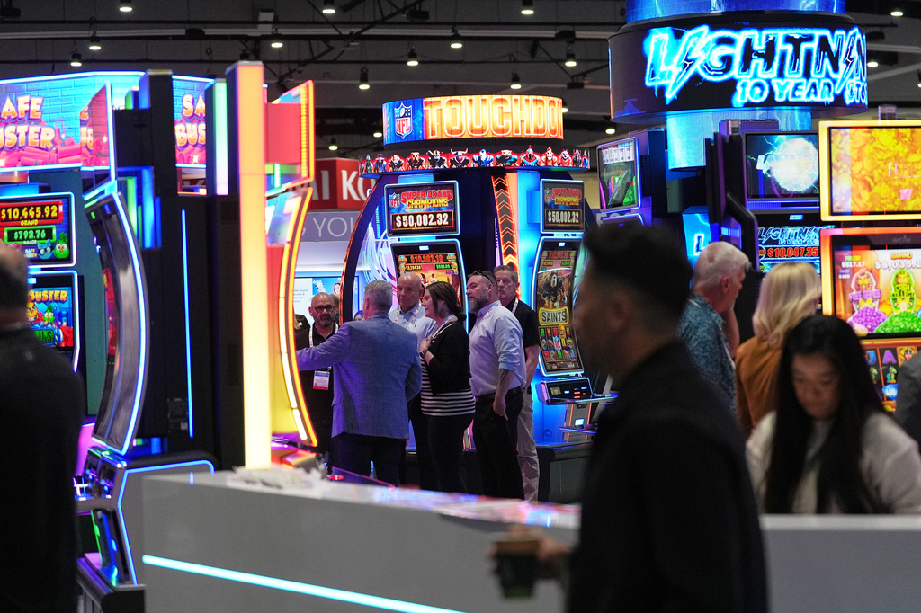Convention attendees pass through displays of products and services for gaming at the Indian Gaming Association's annual convention in San Diego, Thursday, April 2, 2026. (AP Photo/Gregory Bull)