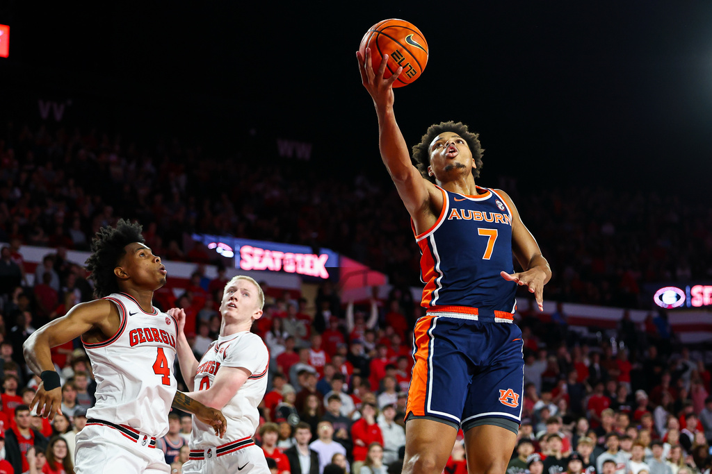 Auburn guard Keyshawn Hall (7) shoots against Georgia guards Marcus Millender, left, and Blue Cain, center, during the first half of an NCAA college basketball game, Saturday, Jan. 3, 2026, in Athens, Ga. (AP Photo/Colin Hubbard)