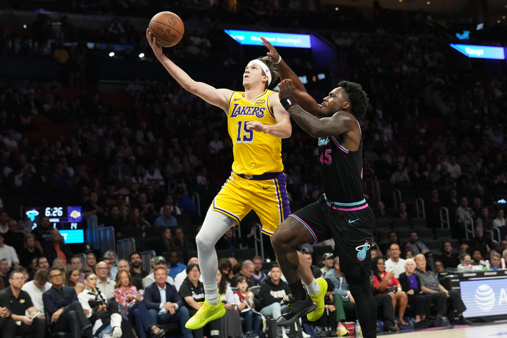 Los Angeles Lakers guard Austin Reaves (15) hopes to the basket as Miami Heat guard Davion Mitchell (45) defends during the first half of an NBA basketball game, Thursday, March 19, 2026, in Miami. (AP Photo/Lynne Sladky)