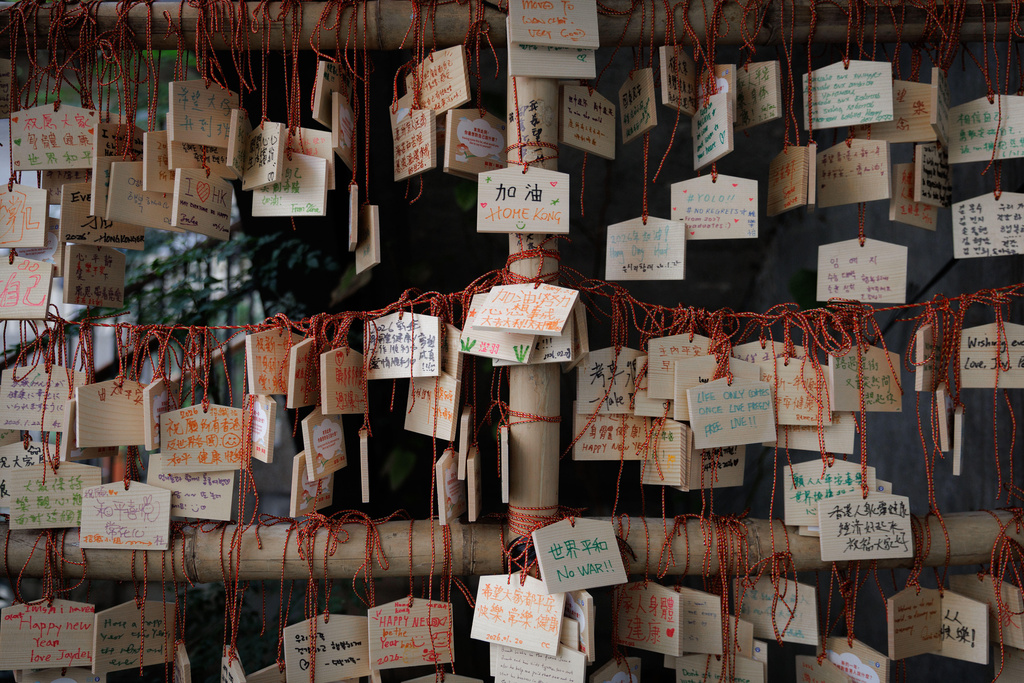 Wooden plaques bearing written wishes are tied with red string at a public site in Hong Kong, Feb. 11, 2026. (AP Photo/May James)