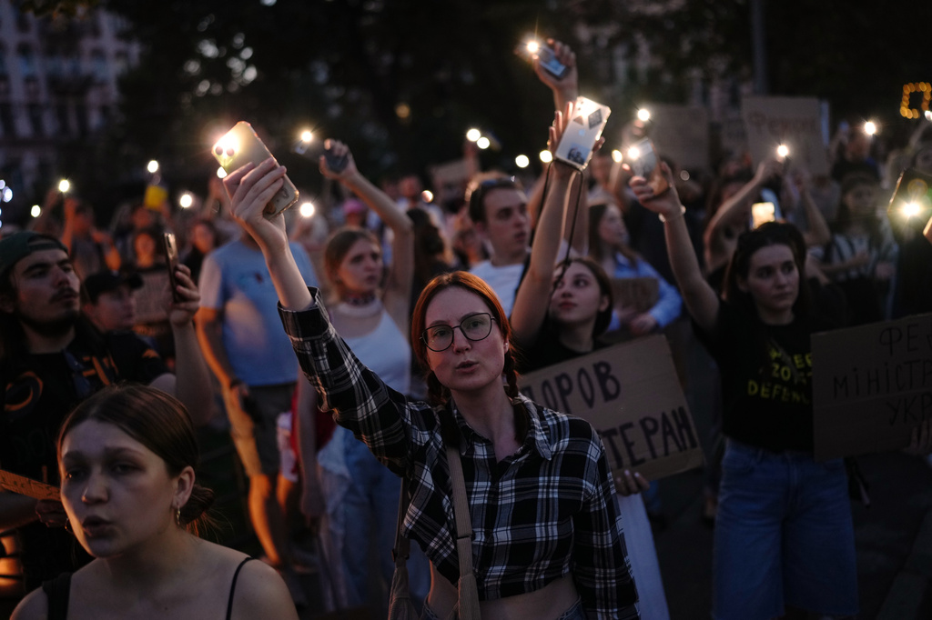 People sing and hold up their cell phone flashlights during a rally to protest the dismissal of Mykhailo Fedorov as Ukraine's Defense Minister in Kyiv, late Sunday, Aug. 16, 2026. (AP Photo/Francisco Seco)