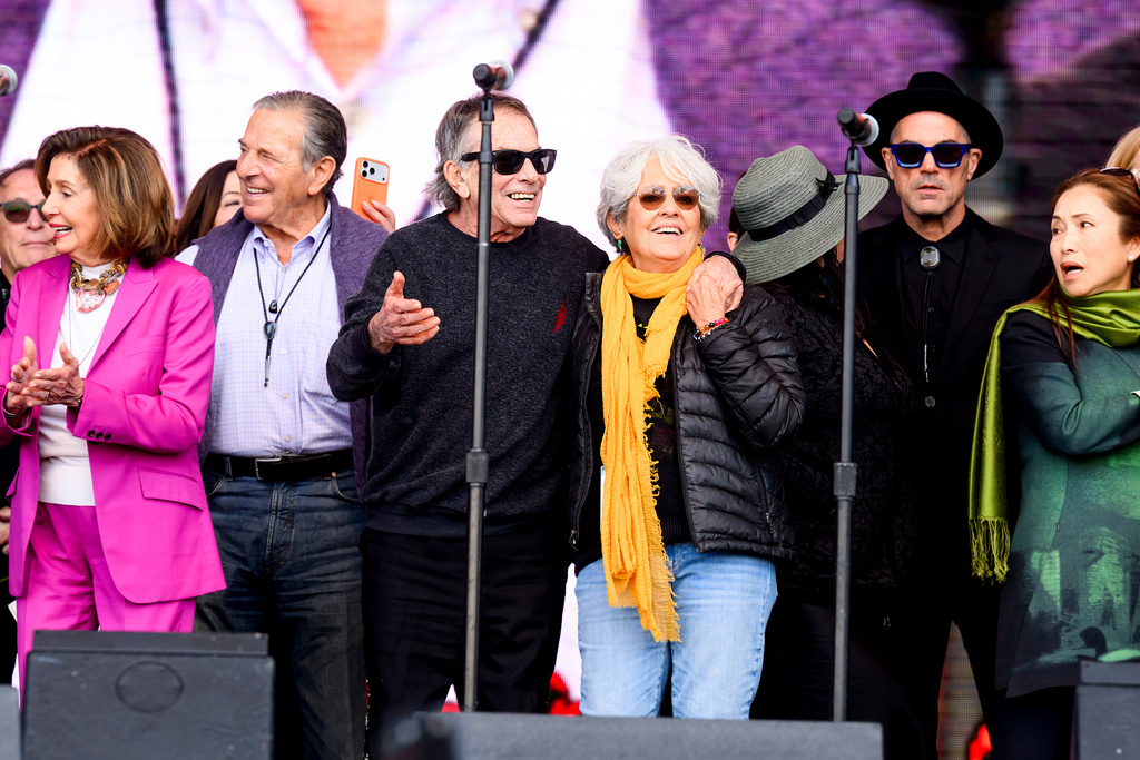 Musicians Joan Baez and Mickey Hart embrace during a memorial for Grateful Dead guitarist Bob Weir on Saturday, Jan. 17, 2026, in San Francisco. At left are Paul and Nancy Pelosi. (AP Photo/Noah Berger)
