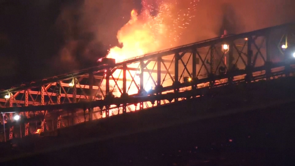 In this image taken from video, a fire breaks out on the Brooklyn Bridge in New York during the city's fireworks celebration on Saturday, July 4, 2026. (AP Photo/Aron Ranen)
