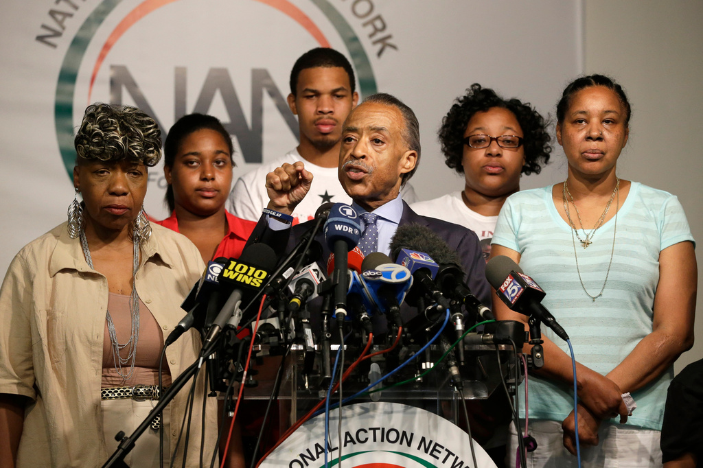 FILE - The Rev. Al Sharpton, center, is joined by Eric Garner's mother Gwen Carr, left, daughter Erica Garner, second from left, son Eric Garner, third from left, daughter Emerald Snipes, second from right, and wife Esaw Snipes, as he speaks during a news conference, Tuesday, July 14, 2015, in New York. (AP Photo/Mary Altaffer, File)
