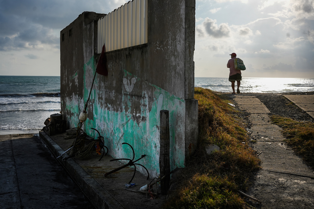 A fisherman stands on the shore after suspending fishing trips because of an oil spill in the Gulf of Mexico that authorities said originated from an unidentified vessel and two natural oil seeps, in Salinas, Mexico, Thursday, March 26, 2026. (AP Photo/Felix Marquez)