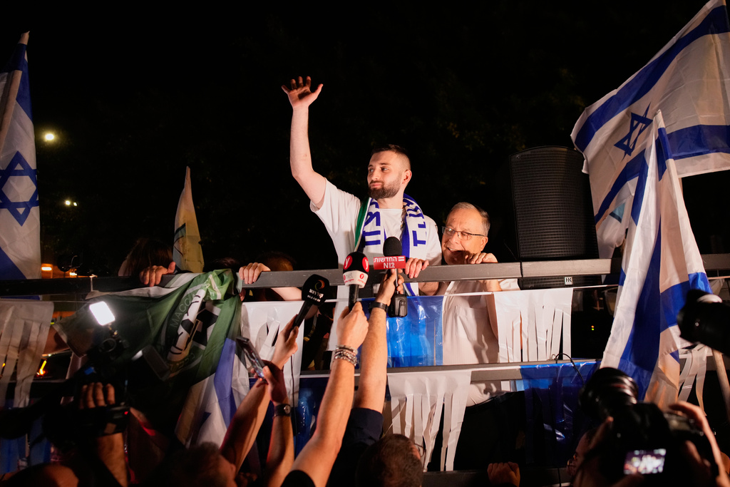 Freed Israeli hostage Matan Angrest, center, who was recently released from Hamas captivity in Gaza, greets supporters upon returning home to Kiryat Bialik, Israel, from the hospital, Thursday, Oct. 23, 2025. (AP Photo/Ohad Zwigenberg)