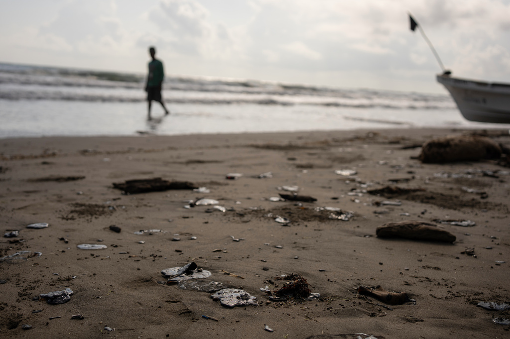 Clumps of oil residue lie on the shore after fishing outings were suspended because of an oil spill that Mexican authorities said originated from an unidentified vessel and two natural oil seeps along the Gulf coast in Salinas, Mexico, Thursday, March 26, 2026. (AP Photo/Felix Marquez)