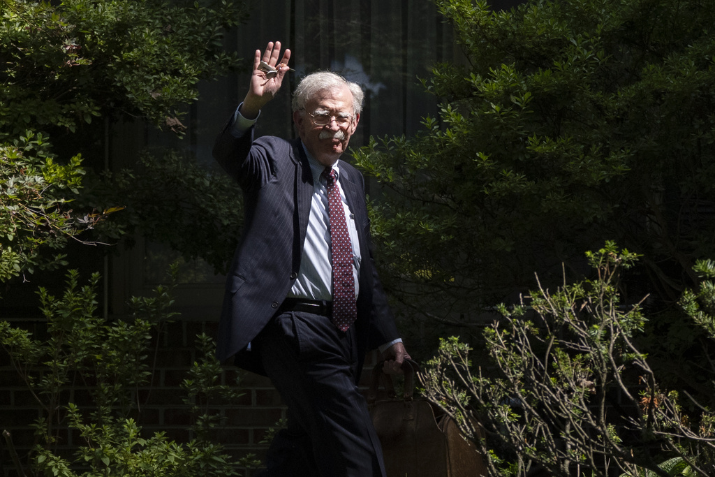 Former national security adviser John Bolton waves as he arrives at his house Friday, Aug. 22, 2025, in Bethesda, Md. (AP Photo/Manuel Balce Ceneta)