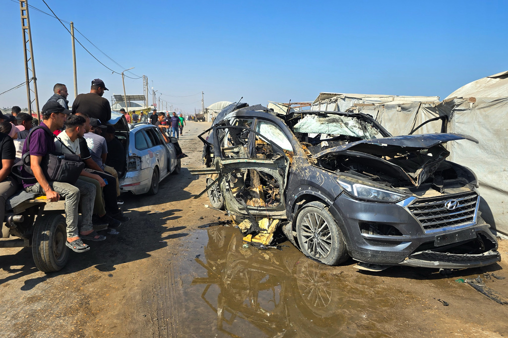 Palestinians look at a destroyed car following an Israeli military strike in Khan Younis, southern Gaza Strip, Monday, July 6, 2026, that, according to hospital officials, killed at least one person. (AP Photo/Mohammad Jahjouh)