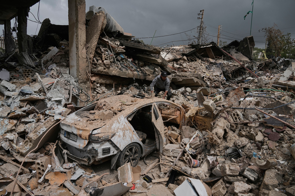 A man inspects his damaged car amid the rubble of shops destroyed in previous Israeli airstrikes in the Hosh neighborhood of Tyre, southern Lebanon, April 19, 2026. (AP Photo/Bilal Hussein)