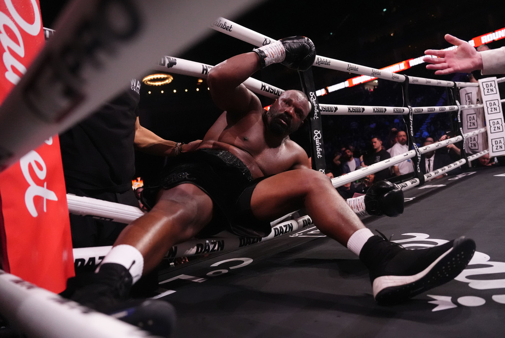 Boxer Derek Chisora falls into the ropes after being knocked down by Deontay Wilder during a fight in London, Saturday April 4, 2026.(Adam Davy/PA via AP)