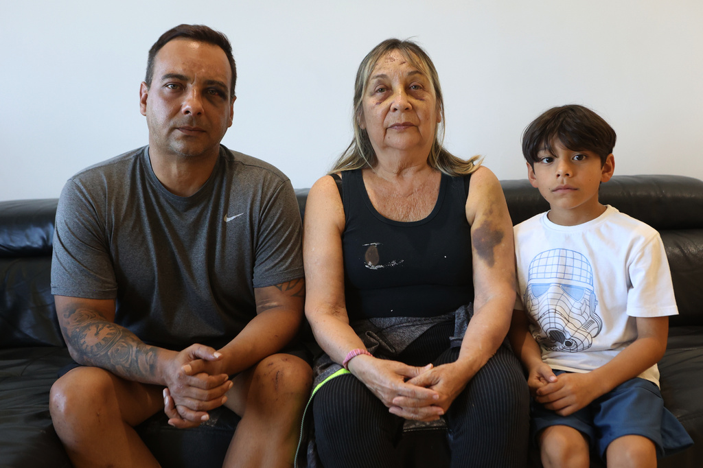 Grian Serrano, left, his mother, Ingrid Rochabrun, and his son, Gael, sit at the home where they are staying with relatives in Caracas, Venezuela, after surviving the back-to-back earthquakes that destroyed their apartment building in Caraballeda, Monday, June 29, 2026. Serrano also survived the 1999 mudslides that struck La Guaira. (AP Photo/Pedro Mattey)