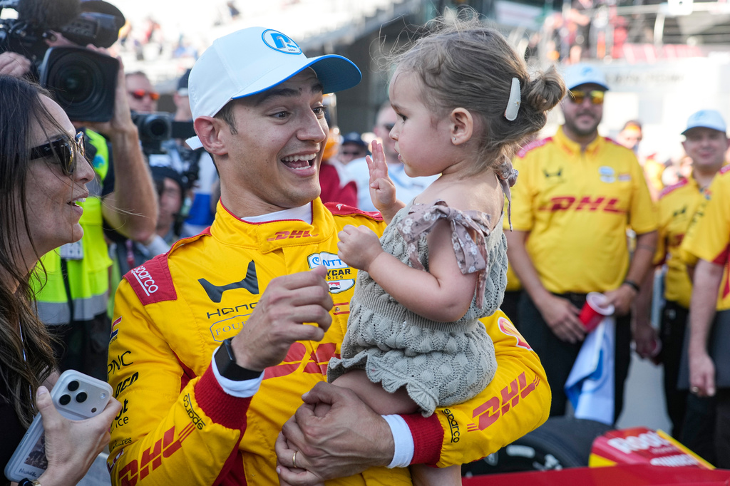 Alex Palou, second from left, of Spain, celebrates with his wife Esther Valle, left, and daughter Lucía after winning the pole during qualifications for the Indianapolis 500 auto race at the Indianapolis Motor Speedway in Indianapolis, Sunday, May 17, 2026. (AP Photo/Michael Conroy)