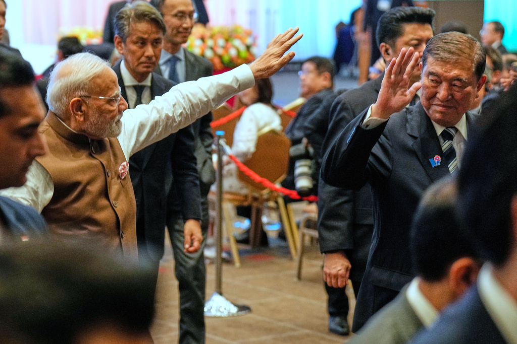 Indian Prime Minister Narendra Modi, left, and Japanese Prime Minister Shigeru Ishiba, right, wave as they leave the venue of the Japan India Economic Forum in Tokyo Friday, Aug. 29, 2025. (AP Photo/Eugene Hoshiko)