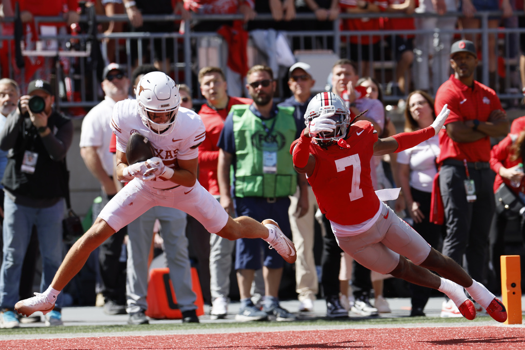 Texas receiver Parker Livingstone, left, catches a touchdown pass in front of Ohio State defensive back Jermaine Mathews during the second half of an NCAA college football game, Saturday, Aug. 30, 2025, in Columbus, Ohio. (AP Photo/Jay LaPrete)