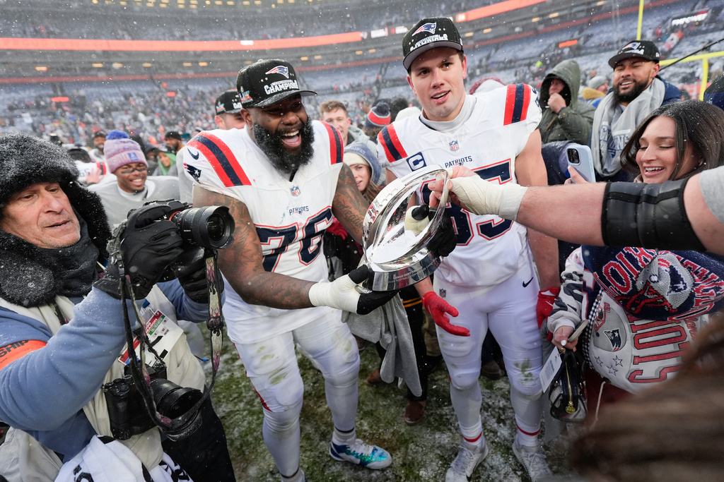 New England Patriots offensive tackle Morgan Moses (76) and tight end Hunter Henry celebrate after the AFC Championship NFL football game against the Denver Broncos, Sunday, Jan. 25, 2026, in Denver. (AP Photo/Ashley Landis)