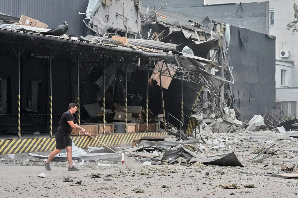 A postal worker clears the debris at the damaged Nova Poshta postal warehouse after Russian missiles strikes in Kyiv, Ukraine, Wednesday, Aug. 5, 2026. (AP Photo/Efrem Lukatsky)