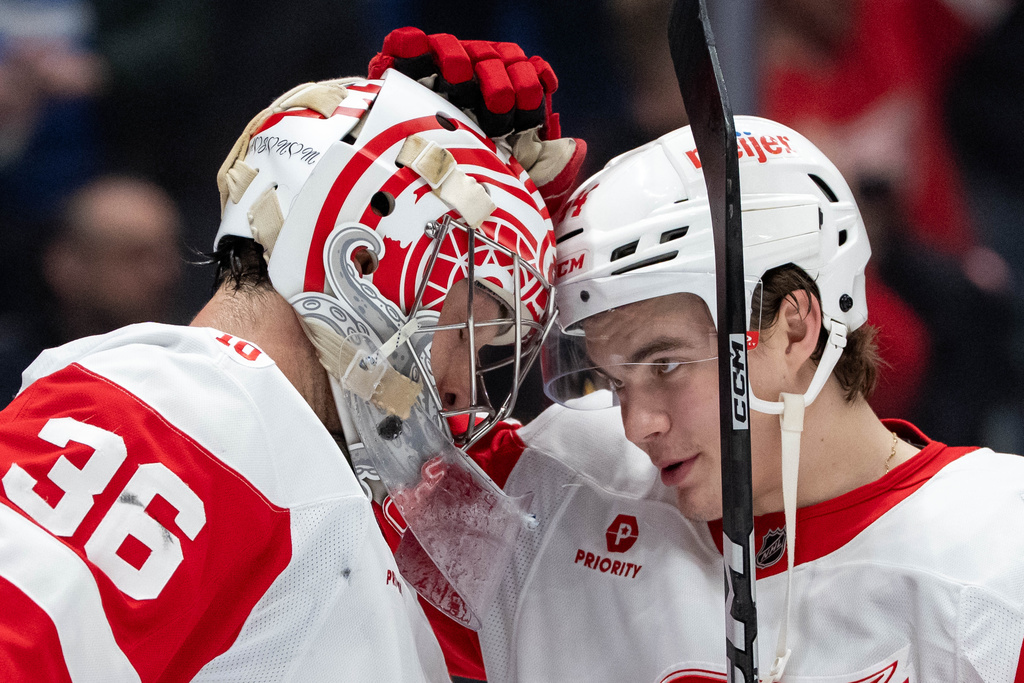 Detroit Red Wings goaltender John Gibson (36) and Axel Sandin-Pellikka (44) celebrate after defeating the Vancouver Canucks during an NHL hockey game in Vancouver, B.C., Monday, Dec. 8, 2025. (Ethan Cairns/The Canadian Press via AP)