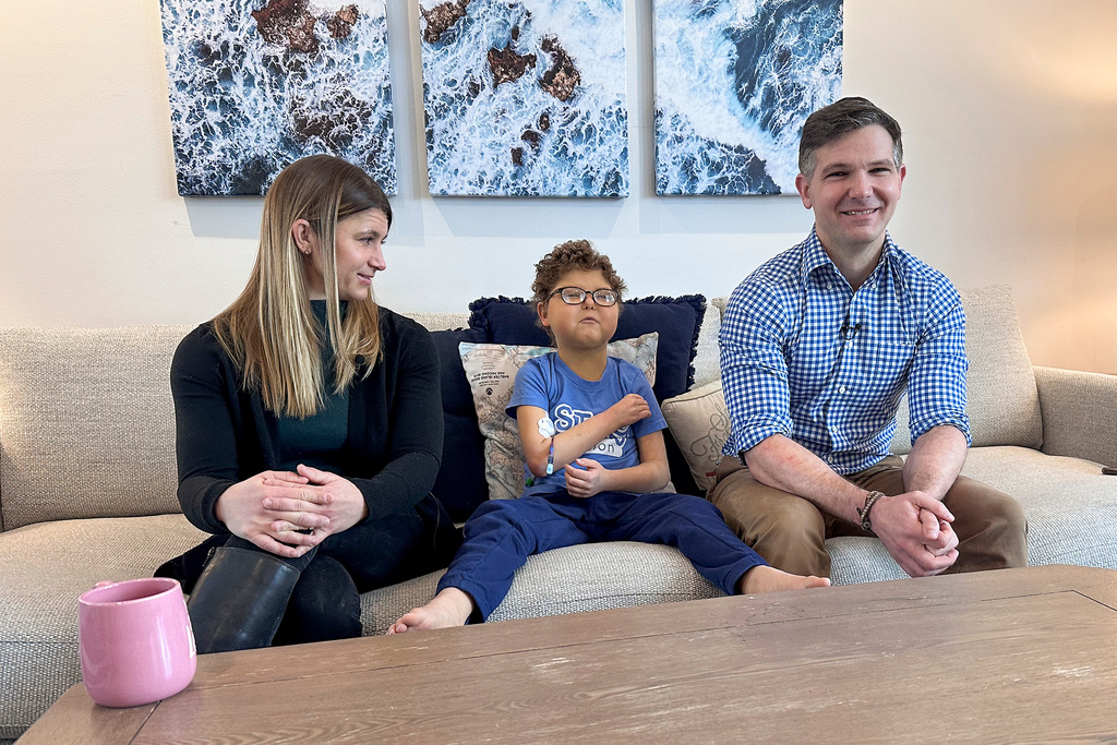 Logan Coyle, nine years old, center, answers questions during an interview with his parents Rebecca Coyle, left, and Logan Coyle, Feb. 10, 2026, in New York. (AP Photo/Phil Marcelo)