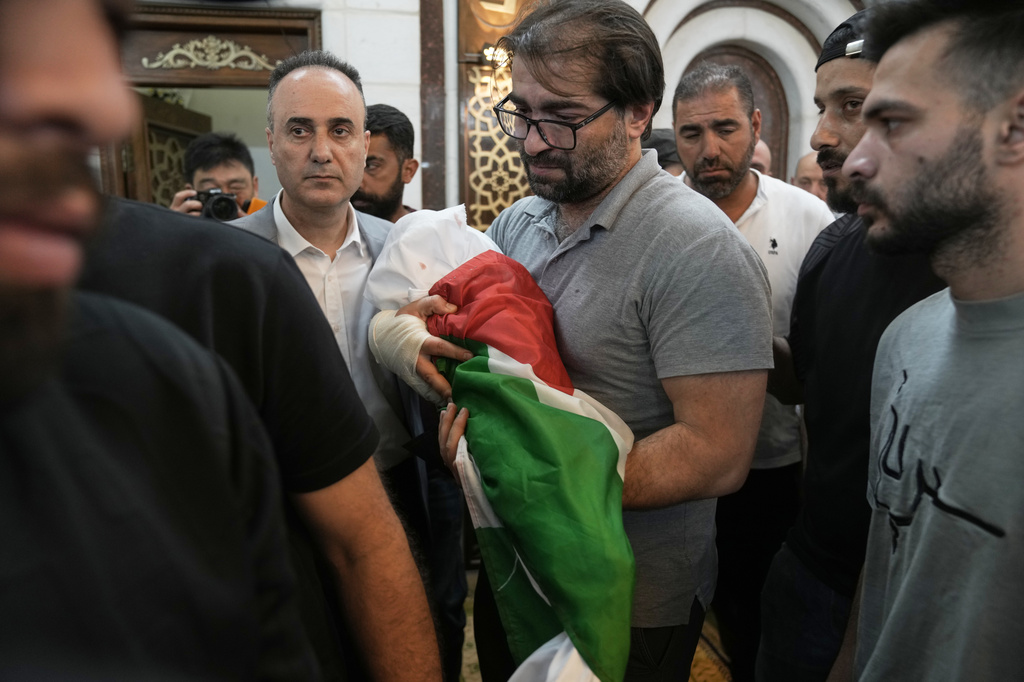 Fahd Abu Haikal, 41 carries the body of his seven month old Palestinian baby boy Sam, who was killed on Friday when, according to the Palestinian health ministry, Israeli soldiers fired at the vehicle carrying him and his parents in Tel Rumeida, during his funeral in the West Bank city of Hebron, Saturday, June 6, 2026. (AP Photo/Mahmoud Illean)