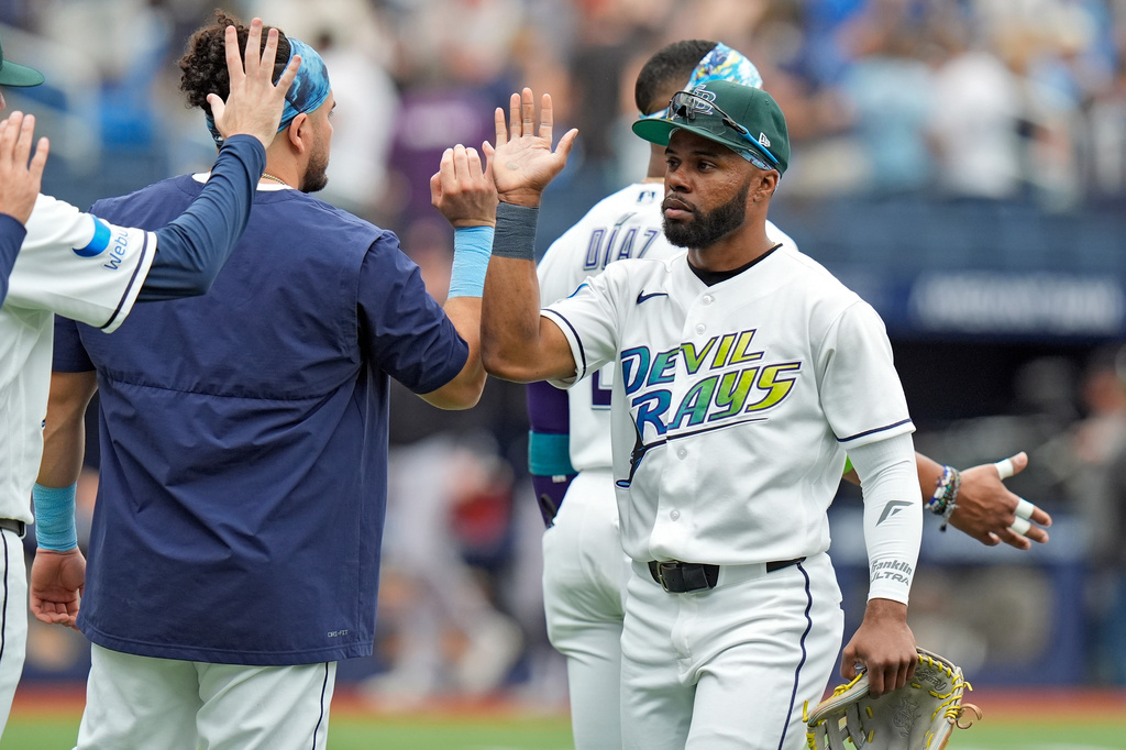Tampa Bay Rays center fielder Cedric Mullins, right, celebrates with teammates after defeating the Cleveland Guardians during a baseball game Sunday, July 26, 2026, in St. Petersburg, Fla. (AP Photo/Chris O'Meara)