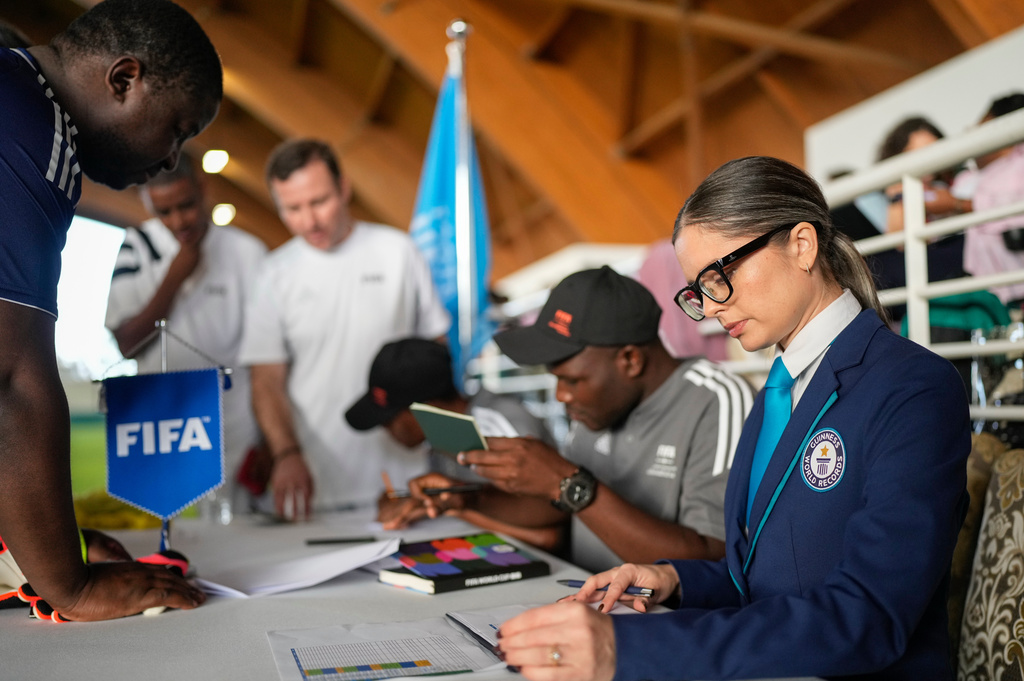 Joanne Brent, front right, Guiness World Records adjudicator, monitors an exhibition soccer match organised by FIFA attempting to break the Guinness World Record for most nationalities in a match, in Rabat, Morocco, Wednesday, Nov. 5, 2025. (AP Photo/Mosa'ab Elshamy)