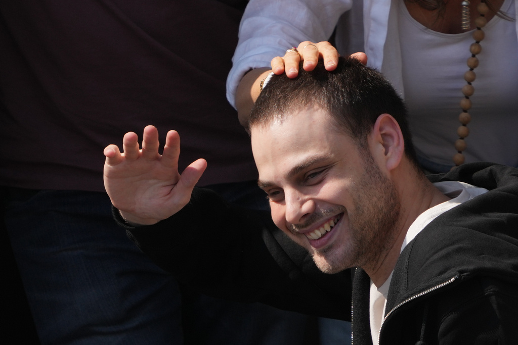 Freed Israeli hostage Alon Ohel gestures from a van as he arrives at Beilinson hospital in Petah Tikva, Israel, after he was released from Hamas captivity in the Gaza Stripl, Monday, Oct. 13, 2025. (AP Photo/Ariel Schalit)
