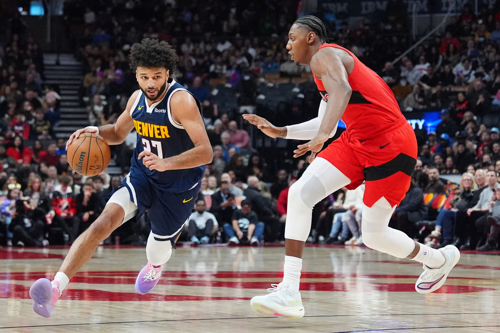 Denver Nuggets guard Jamal Murray (27) moves around Toronto Raptors forward/guard RJ Barrett, right, during first half NBA action in Toronto on Wednesday Dec. 31, 2025. (Frank Gunn/The Canadian Press via AP)