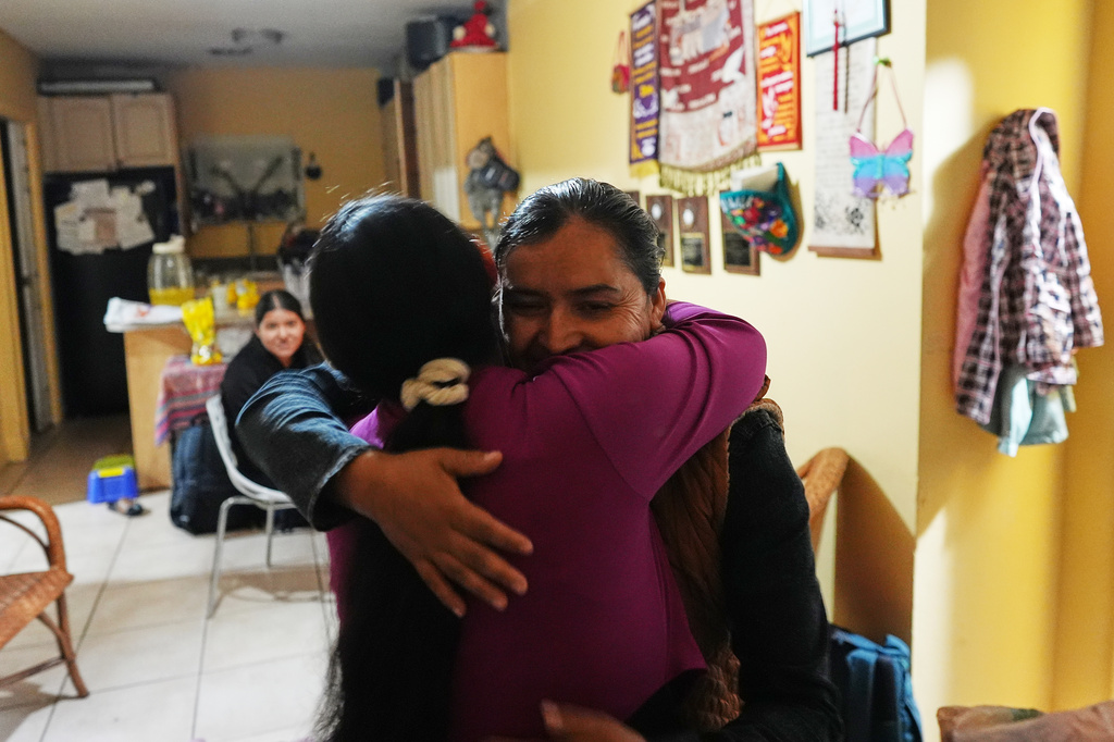 Mirsy Maricela Alva Lopez, right, embraces a relative as she and her children return to the home they all shared in West Palm Beach, Fla., nearly one year after being separated by the U.S. government for the second time, Thursday, May 28, 2026. (AP Photo/Rebecca Blackwell)