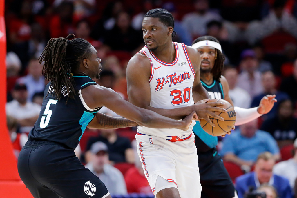 Portland Trail Blazers guard Jrue Holiday (5) reaches in as Houston Rockets center Clint Capela (30) looks to pass the ball during the first half of an NBA basketball game Friday March 6, 2026, in Houston. (AP Photo/Michael Wyke)