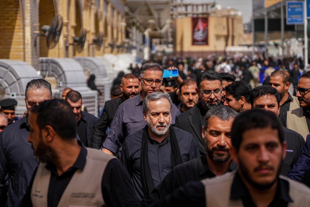 Iran's Foreign Minister Abbas Araghchi, center, is surrounded by security personnel as he walks in Najaf, Iraq, during Arbaeen commemorations, Monday, Aug. 3, 2026. (AP Photo/Anmar Khalil)