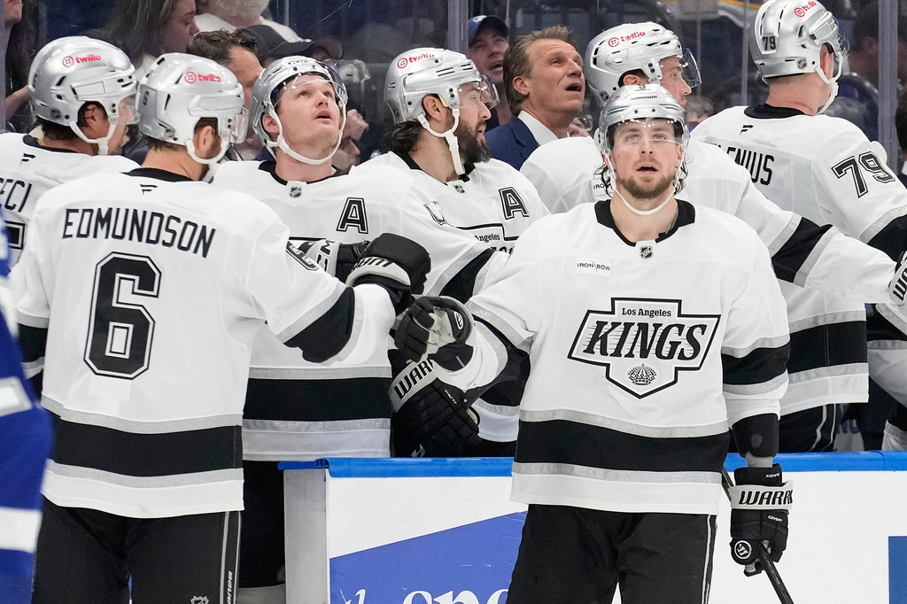 Los Angeles Kings right wing Adrian Kempe (9) celebrates with the bench, including defenseman Joel Edmundson (6) after scoring against the Tampa Bay Lightning during the second period of an NHL hockey game Thursday, Dec. 18, 2025, in Tampa, Fla. (AP Photo/Chris O'Meara)