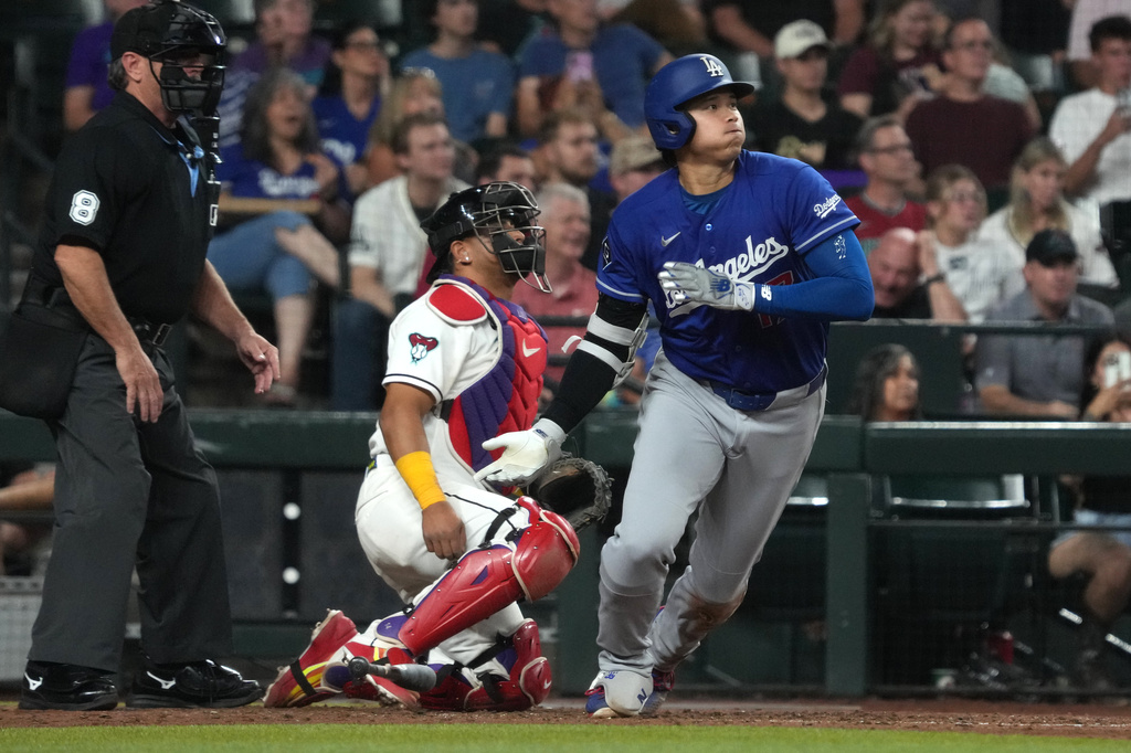 Los Angeles Dodgers' Shohei Ohtani, right, watches his single against the Arizona Diamondbacks in the fifth inning of a baseball game, Monday, June 1, 2026, in Phoenix. (AP Photo/Rick Scuteri)