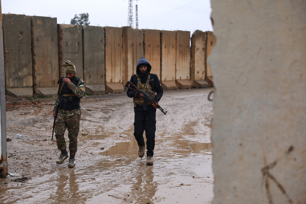 Syrian government forces walk in the al-Aqtan prison after taking control of it from the Kurdish-led Syrian Democratic Forces, SDF, in Raqqa, northeastern Syria, Friday, Jan. 23, 2026. (AP Photo/Ghaith Alsayed)
