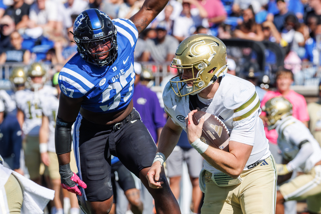 Georgia Tech's Haynes King, right, carries the ball ahead of Duke's Wesley Williams (97) during the second half of an NCAA college football game in Durham, N.C., Saturday, Oct. 18, 2025. (AP Photo/Ben McKeown)