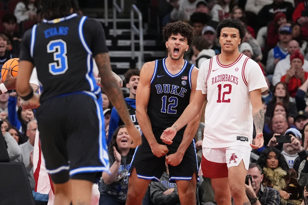 Duke forward Cameron Boozer (12) celebrates after scoring as Arkansas forward Malique Ewin (12) looks on during the second half of an NCAA college basketball game in the CBS Sports Thanksgiving Classic tournament Thursday, Nov. 27, 2025, in Chicago. (AP Photo/Nam Y. Huh)