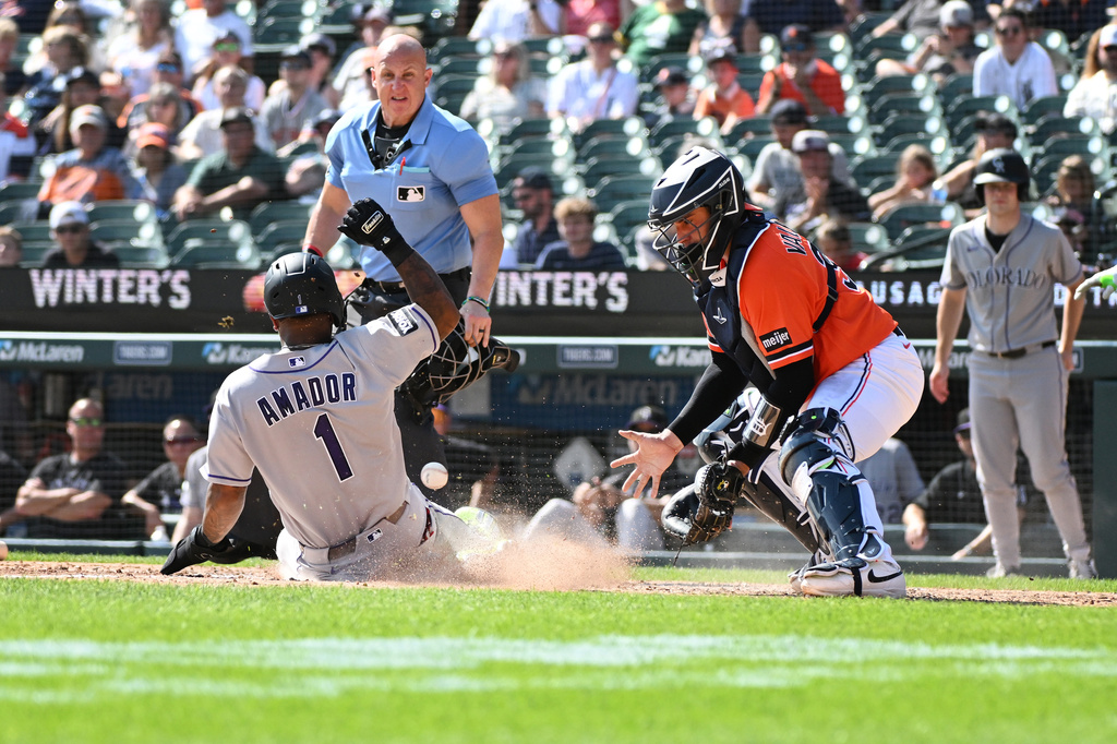 Colorado Rockies' Adael Amador (1) slides to score a run as Detroit Tigers catcher Eduardo Valencia looks at the ball during the sixth inning of a baseball game, Saturday, Sept. 12, 2026, in Detroit. (AP Photo/Jose Juarez)