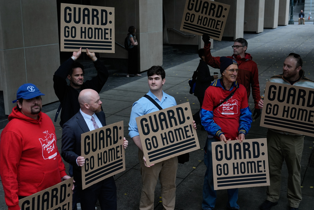 Army veteran and Portland City Council member Mitch Green, second from left, stands with protesters outside a federal courthouse on Friday, Oct. 3, 2025, in Portland, Ore., before a federal court hearing on Oregon's bid to temporarily block President Donald Trump's deployment of the National Guard to Portland is held inside. (AP Photo/Jenny Kane)