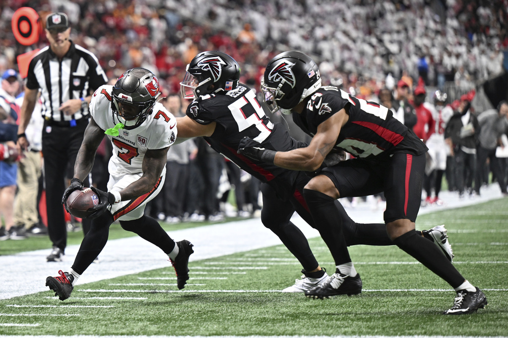 Tampa Bay Buccaneers running back Bucky Irving (7) runs in for a touchdown against Atlanta Falcons cornerback A.J. Terrell Jr. (24) and defensive tackle Brandon Dorlus (54) during the second half of an NFL football game, Sunday, Sept. 7, 2025, in Atlanta. (AP Photo/Danny Karnik)