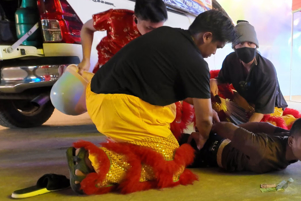 In this image released by Thailand’s Metropolitan Police Bureau, Thai police disguised as lion dance performers catch a burglary suspect at a temple fair in Nonthaburi province, Wednesday, Feb. 18, 2026. (The Metropolitan Police Bureau via AP)