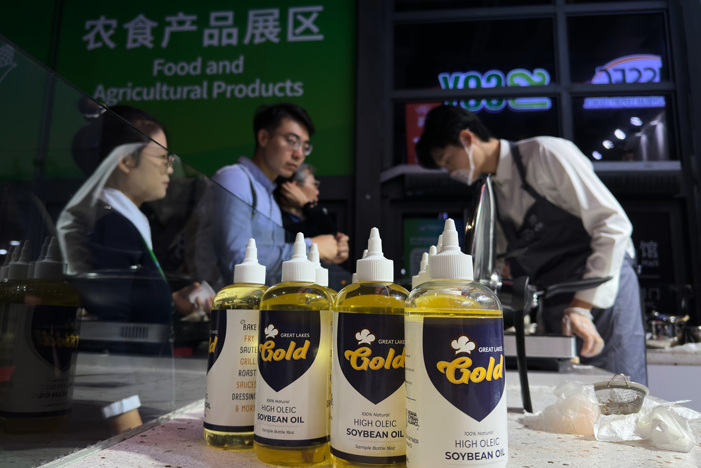 Visitors wait to try out the snack foods cooked with U.S. soybean oil at the U.S. Soybean Export Council exhibition booth during the China International Import Expo, in Shanghai, China, Thursday, Nov. 6, 2025. (AP Photo/Wayne Zhang)
