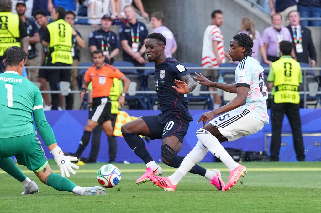 United States' Folarin Balogun (20) tries to score on Belgium goalkeeper Thibaut Courtois (1) during the World Cup round of 16 soccer match in Seattle, Monday, July 6, 2026. (AP Photo/Ted S. Warren)