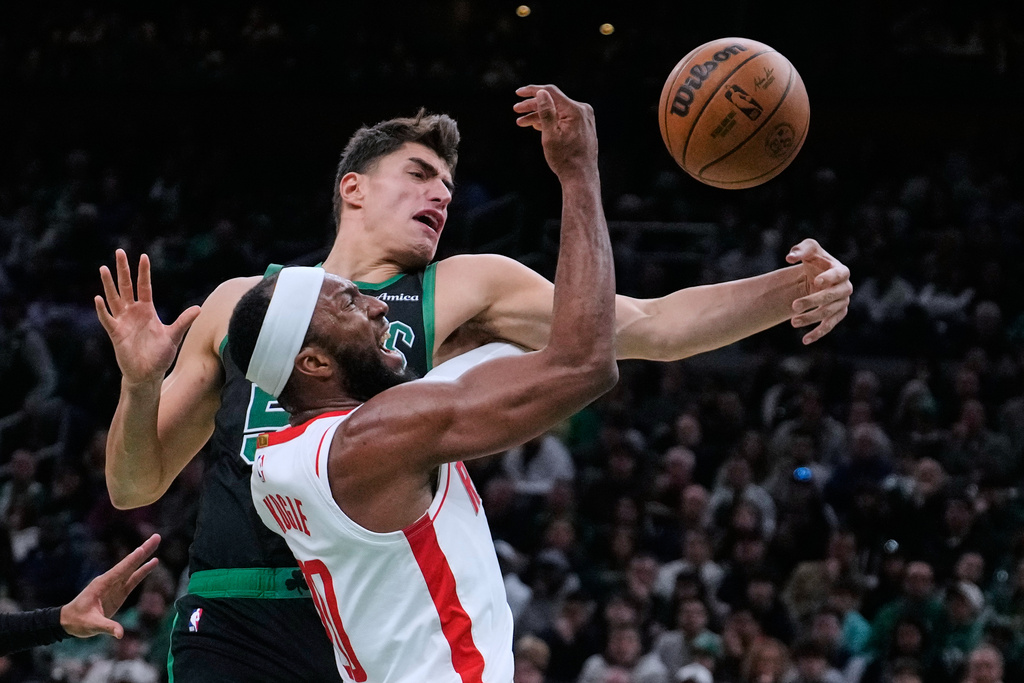 Houston Rockets guard Josh Okogie, bottom, battles for the ball against Boston Celtics center Luka Garza during the second half of an NBA basketball game, Saturday, Nov. 1, 2025, in Boston. (AP Photo/Charles Krupa)