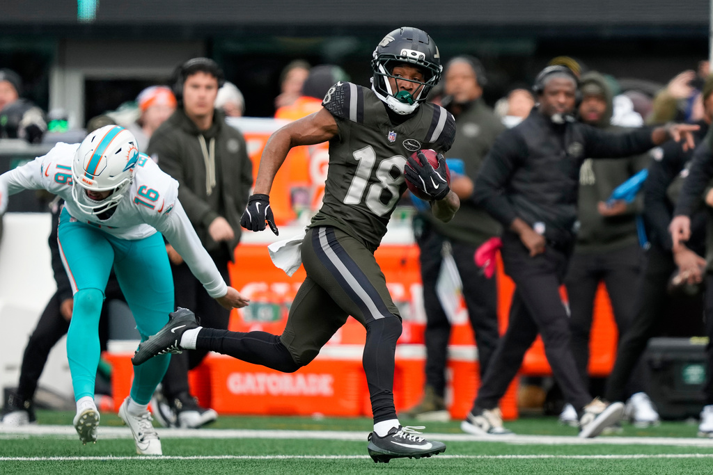 New York Jets wide receiver Isaiah Williams (18) returns a punt for a touchdown against the Miami Dolphins during the first quarter of an NFL football game, Sunday, Dec. 7, 2025, in East Rutherford, N.J. (AP Photo/Yuki Iwamura)