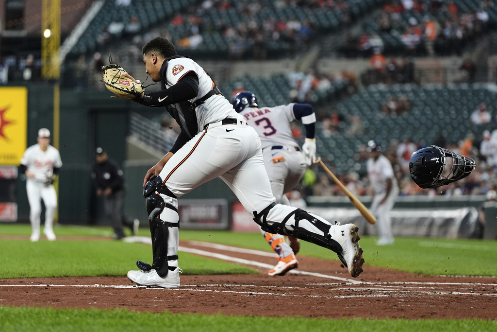 Baltimore Orioles catcher Sam Basallo, left, fields a ground ball hit by Houston Astros' Jeremy Pena (3) to make the out at first base during the second inning of a baseball game, Thursday, Aug. 21, 2025, in Baltimore. (AP Photo/Stephanie Scarbrough)