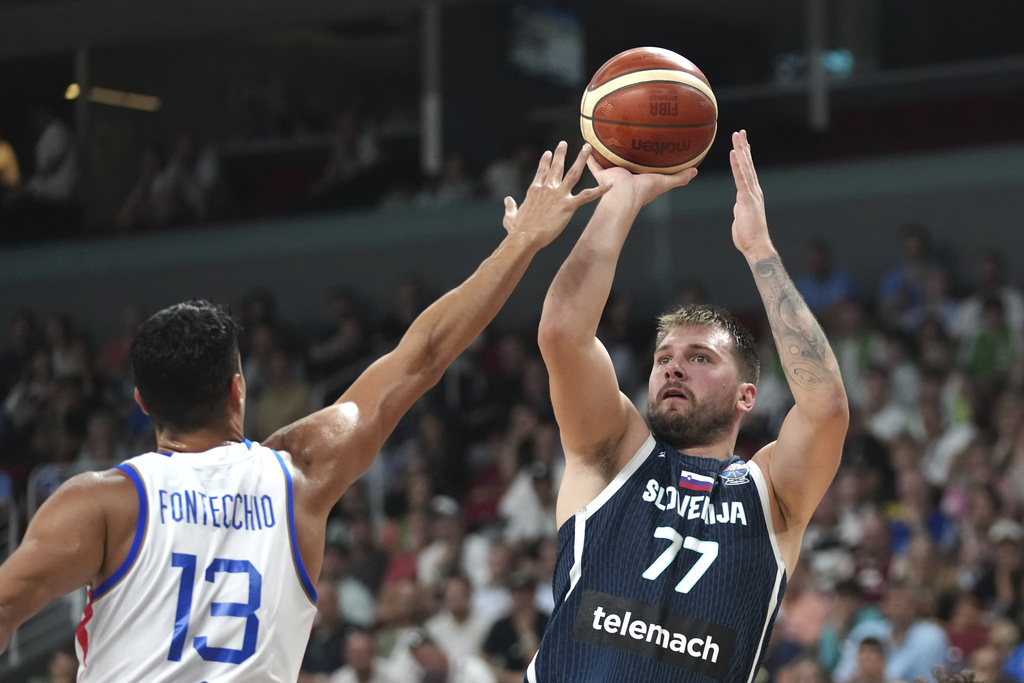 Slovenia's Luka Doncic tries to shoot while defended by Italy's Simone Fontecchio during the Eurobasket, European Basketball Championship round of 16 match between Italy and Slovenia at the Riga Arena in Riga, Latvia, Sunday, Sept. 7, 2025. (AP Photo/Sergei Grits)