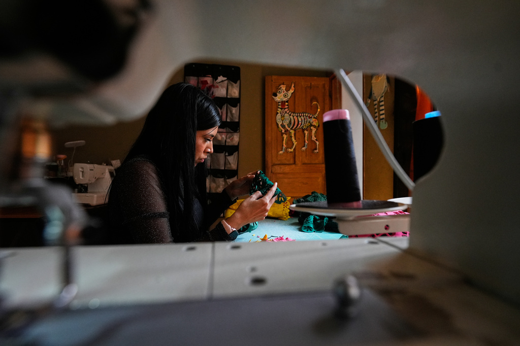 Cande Martinez prepares soccer jerseys, inspired by papel picado and traditional folk art, from the brand Mexclart, in Cuautitlán Izcalli, Mexico, Monday, May 25, 2026. (AP Photo/Marco Ugarte)