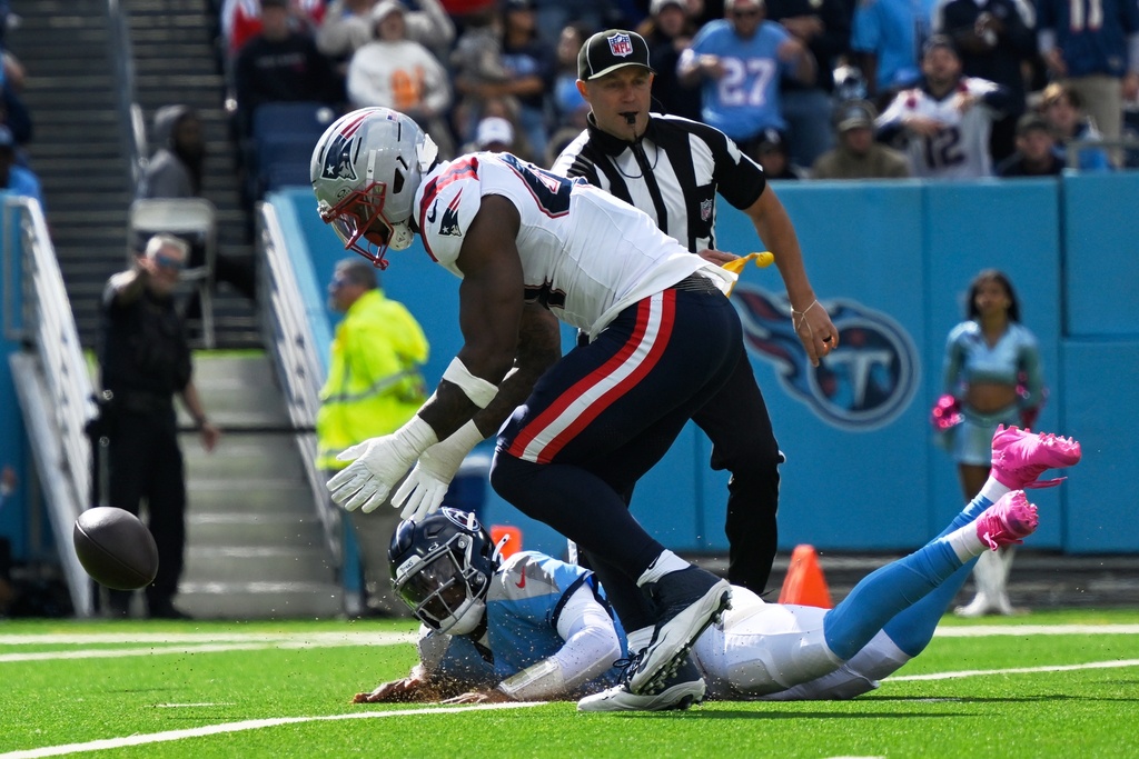 New England Patriots linebacker K'Lavon Chaisson (44) recovers a fumble by Tennessee Titans quarterback Cam Ward (1) for a touchdown during the second half of an NFL football game, Sunday, Oct. 19, 2025, in Nashville, Tenn. (AP Photo/John Amis)